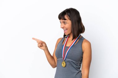 Young mixed race woman with medals isolated on white background pointing finger to the side and presenting a product