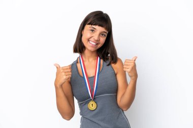 Young mixed race woman with medals isolated on white background with thumbs up gesture and smiling