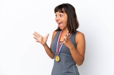 Young mixed race woman with medals isolated on white background with surprise facial expression