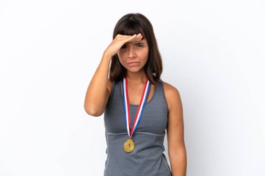 Young mixed race woman with medals isolated on white background looking far away with hand to look something
