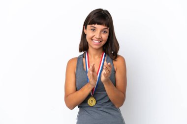 Young mixed race woman with medals isolated on white background applauding after presentation in a conference