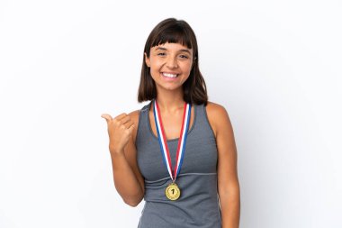 Young mixed race woman with medals isolated on white background pointing to the side to present a product