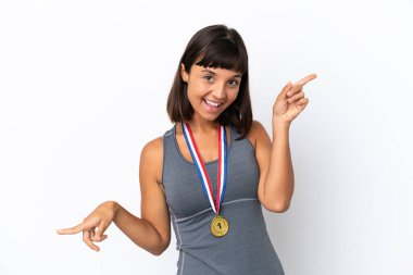 Young mixed race woman with medals isolated on white background pointing finger to the laterals and happy