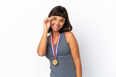 Young mixed race woman with medals isolated on white background with glasses and happy