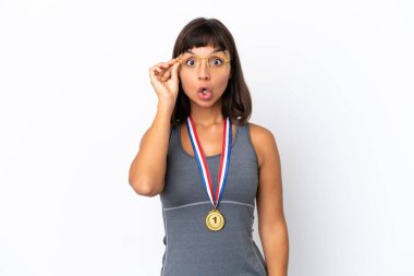 Young mixed race woman with medals isolated on white background with glasses and surprised