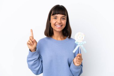 Young mixed race woman holding a lollipop isolated on white background pointing up a great idea