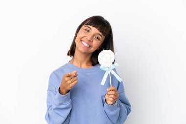 Young mixed race woman holding a lollipop isolated on white background pointing front with happy expression