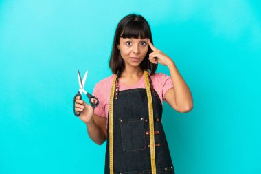 Young mixed race seasmtress woman isolated on blue background thinking an idea