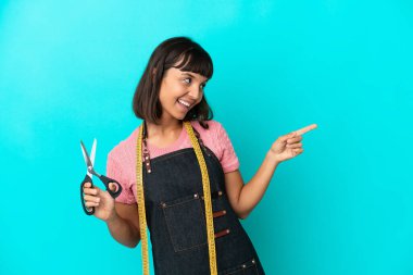 Young mixed race seasmtress woman isolated on blue background pointing finger to the side and presenting a product