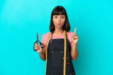 Young mixed race seasmtress woman isolated on blue background intending to realizes the solution while lifting a finger up