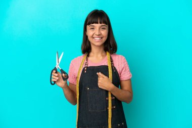 Young mixed race seasmtress woman isolated on blue background with surprise facial expression