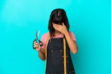 Young mixed race seasmtress woman isolated on blue background with tired and sick expression