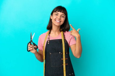 Young mixed race seasmtress woman isolated on blue background giving a thumbs up gesture