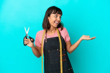 Young mixed race seasmtress woman isolated on blue background with surprise expression while looking side