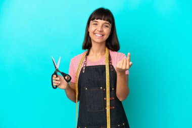 Young mixed race seasmtress woman isolated on blue background doing coming gesture