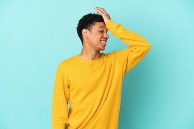 Mavi arka planda izole edilmiş genç Afro-Amerikan bir şey fark etti ve çözüme niyetlendi.