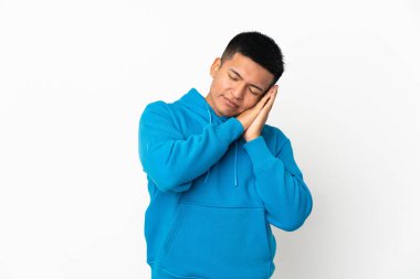 Beyaz arka planda izole edilmiş genç Ekvadorlu adam hareketli uyku hareketleri yapıyor.