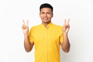 Beyaz arka planda izole edilmiş genç Ekvadorlu iki eliyle zafer işareti gösteriyor.