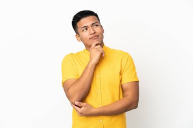 Genç Ekvadorlu adam beyaz arka planda izole edilmiş ve yukarı bakıyor.