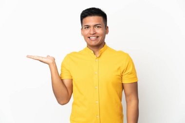 Beyaz arka planda izole edilmiş genç Ekvadorlu bir adam bir ilan vermek için avucunun içinde hayali bir kopyalama alanı tutuyor.