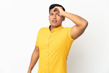 Beyaz arka planda izole edilmiş genç Ekvadorlu bir adam yan tarafa bakarken sürpriz jest yapıyor.