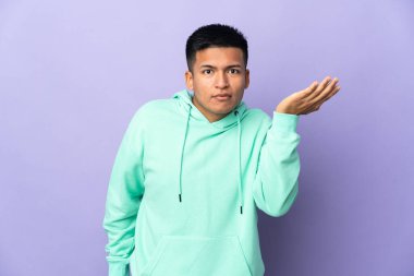 Genç Ekvadorlu, mor arka planda izole edilmiş şüpheli hareketler yapıyor.