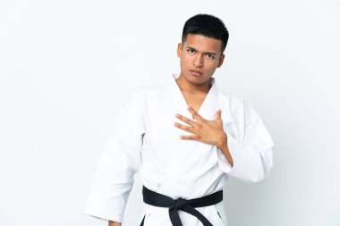 Beyaz arka planda karate yapan genç Ekvadorlu adam sağa bakarken şaşırmış ve şok olmuştu.