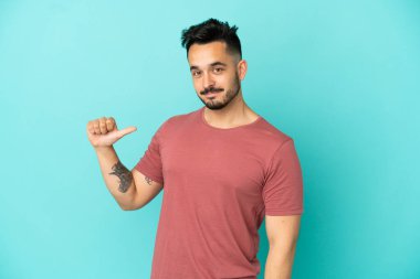 Kafkasyalı genç adam mavi arka planda soyutlanmış gururlu ve kendini beğenmiş.
