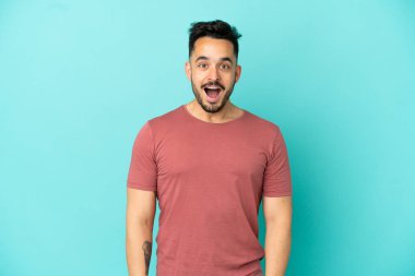 Mavi arka planda yalıtılmış beyaz bir adam. Şaşırtıcı bir yüz ifadesi var.