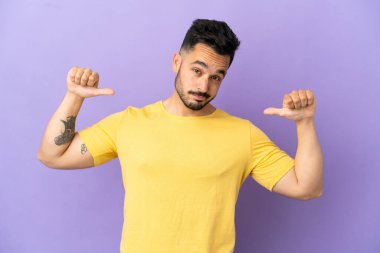 Mor arka planda soyutlanmış, gururlu ve kendini beğenmiş genç beyaz bir adam.