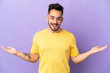 Yüzünde şok ifadesi olan, mor arka planda izole edilmiş genç beyaz bir adam.