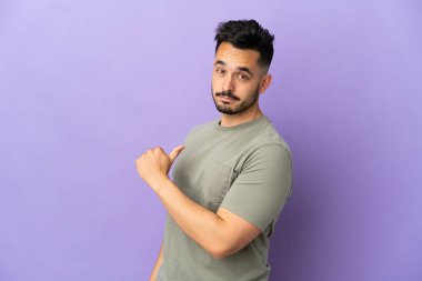 Mor arka planda soyutlanmış, gururlu ve kendini beğenmiş genç beyaz bir adam.