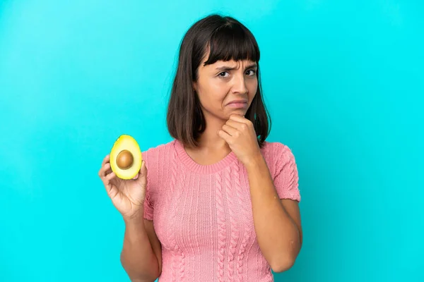 Young Mixed Race Woman Holding Avocado Isolated Blue Background Having — Stockfoto