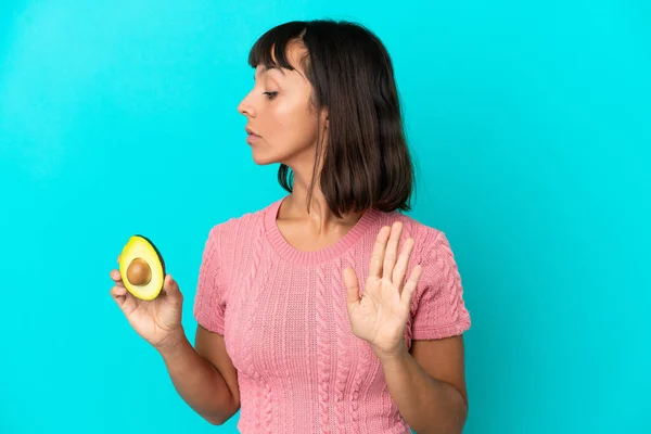 Young Mixed Race Woman Holding Avocado Isolated Blue Background Making — Stockfoto