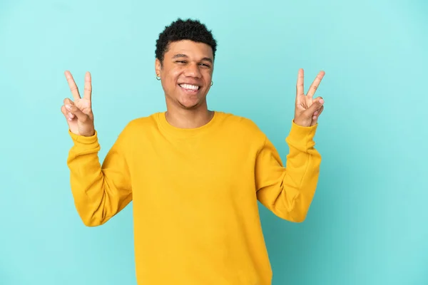 Joven Afroamericano Aislado Sobre Fondo Azul Mostrando Signo Victoria Con — Foto de Stock