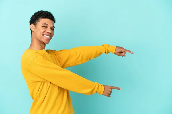 Joven Afroamericano Aislado Sobre Fondo Azul Apuntando Con Dedo Hacia — Foto de Stock