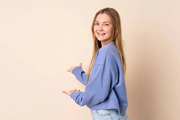 Adolescente Ucraniana Chica Aislado Fondo Beige Extendiendo Las Manos Lado —  Fotos de Stock