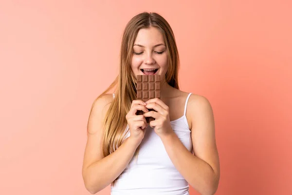 Teenager Ukrajinská Dívka Izolované Růžovém Pozadí Jíst Čokoládové Tablety — Stock fotografie