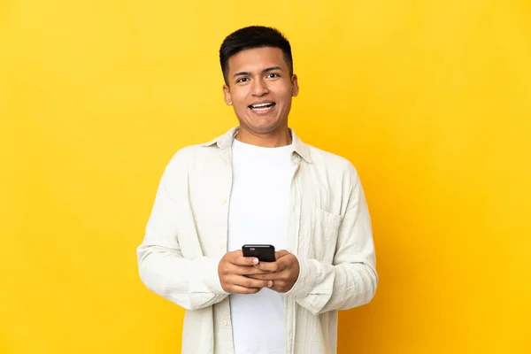 Young Ecuadorian Man Isolated Yellow Background Surprised Sending Message — стокове фото