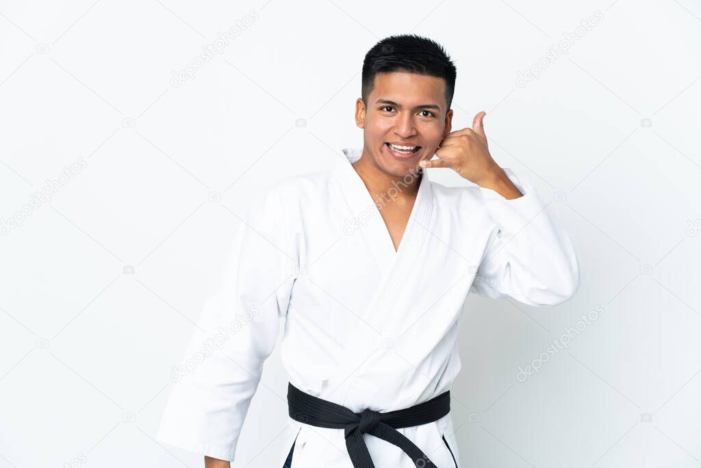 Young Ecuadorian man doing karate isolated on white background making phone gesture. Call me back sign