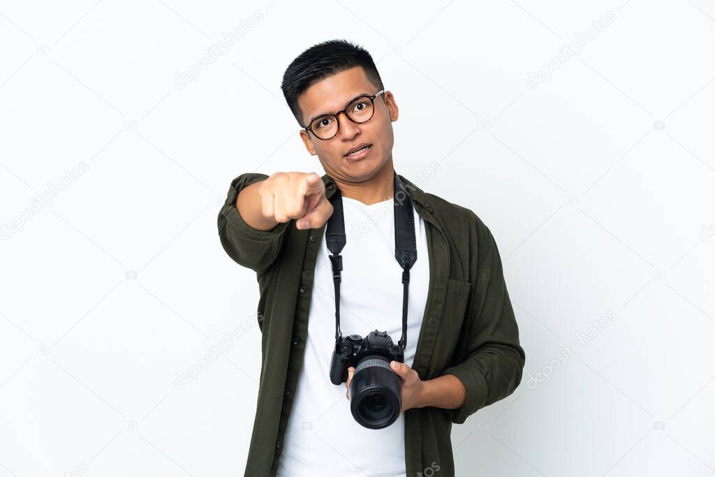 Young Ecuadorian photographer isolated on white background surprised and pointing front