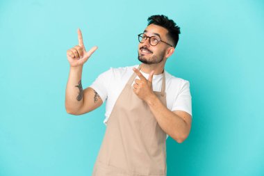 Restoran garsonu beyaz adam mavi arka planda izole edilmiş işaret parmağıyla işaret etmek harika bir fikir.