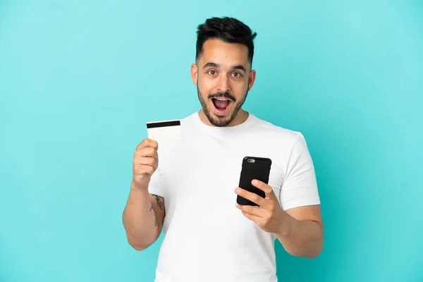 Kafkasyalı Genç Adam Mavi Arka Planda Izole Edilmiş Cep Telefonuyla — Stok fotoğraf