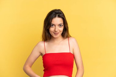 Sarı arka planda izole edilmiş genç beyaz kadın gülüyor.