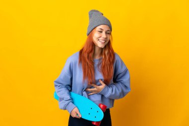 Genç Rus patenci kız sarı arka planda izole edilmiş, çok gülümsüyor.