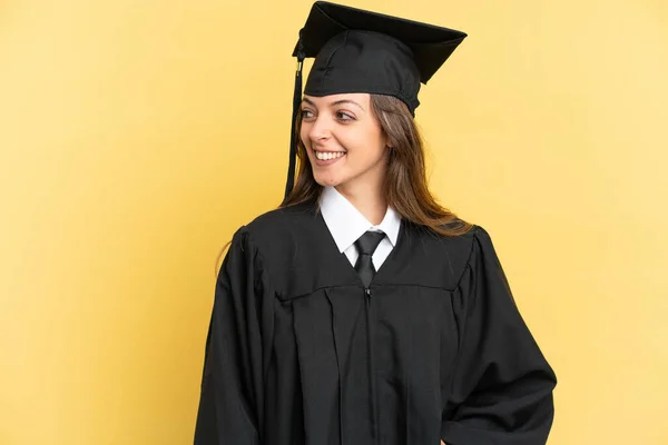 Fiatal Egyetemi Diplomás Elszigetelt Sárga Háttér Látszó Oldalon — Stock Fotó