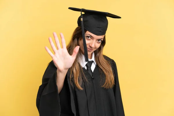 Young University Graduate Isolated Yellow Background Counting Five Fingers — стоковое фото