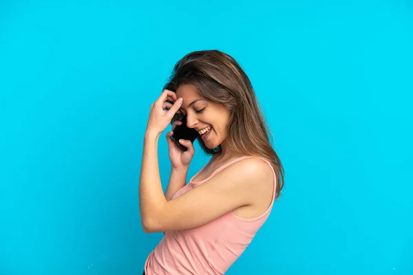 Mladý Kavkazský Žena Pomocí Mobilního Telefonu Izolované Modrém Pozadí Smích — Stock fotografie