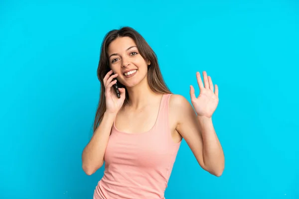 Giovane Donna Caucasica Utilizzando Telefono Cellulare Isolato Sfondo Blu Saluti — Foto Stock
