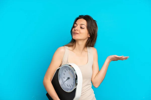 Mujer Joven Caucásica Aislada Sobre Fondo Azul Con Máquina Pesaje — Foto de Stock